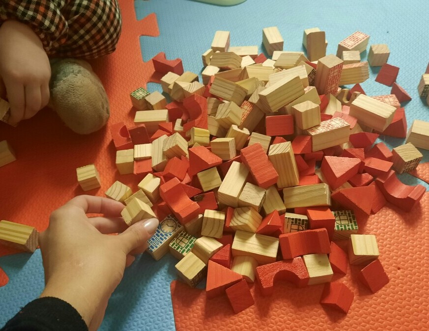 Child placing shapes into a wooden sorter